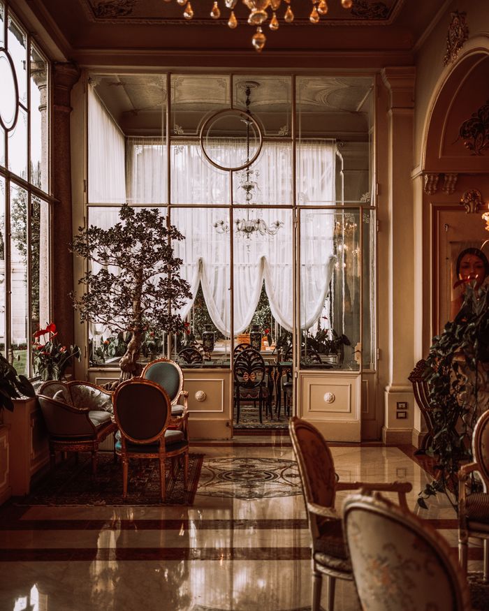 Elegant classic luxury interior of a grand hotel in Stresa, Italy with ornate furnishings.
