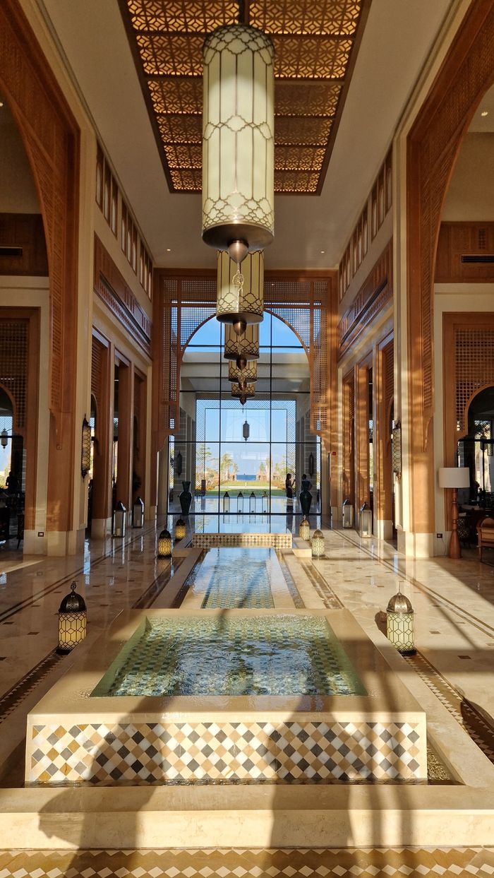 Spacious hotel lobby with traditional decor and sunlight streaming in.