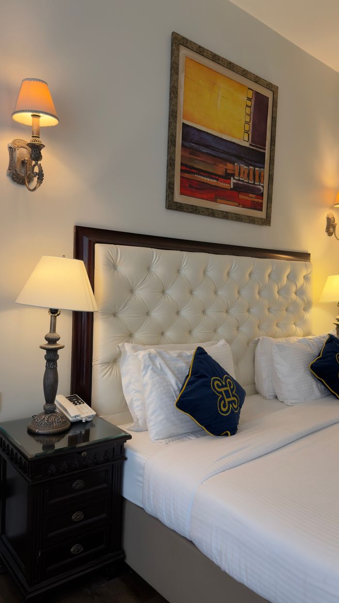 Elegant hotel room with plush bed, artistic decor, and soft lighting for ultimate relaxation.